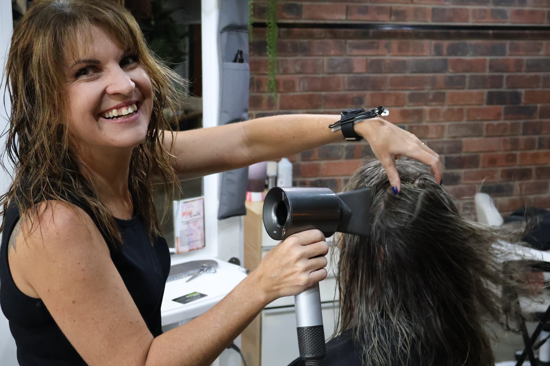 Kate blow-drying a client in the salon